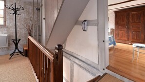 A staircase with wooden railings, a coat rack, and a wall-mounted light fixture. - Charming Alsatian gîte near Colmar - 6 guests (Jebsheim)