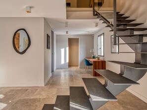 Ein modernes Interieur mit Treppe, Schreibtisch und Spiegel.