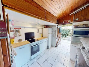 A compact kitchen with white cabinets, a stove, oven, and a refrigerator.
