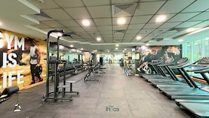 Ein Fitnessstudio mit Laufbändern, Kraftgeräten und einer motivierenden Wand.