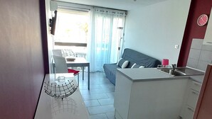 Una cocina moderna con zona de comedor, sofá y ventana con cortinas.