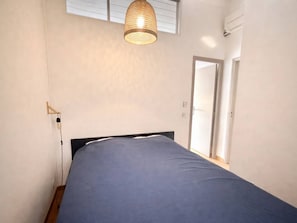 A bedroom with a bed, a hanging light fixture, a door, and a window. - Bright house with AC, terrace & parking, close to beach (Lecci)