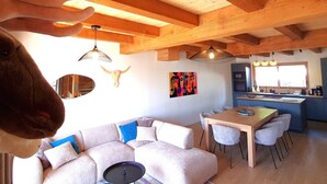 Ein gemütliches Interieur mit Holzbalkendecke, Essbereich und Küche.