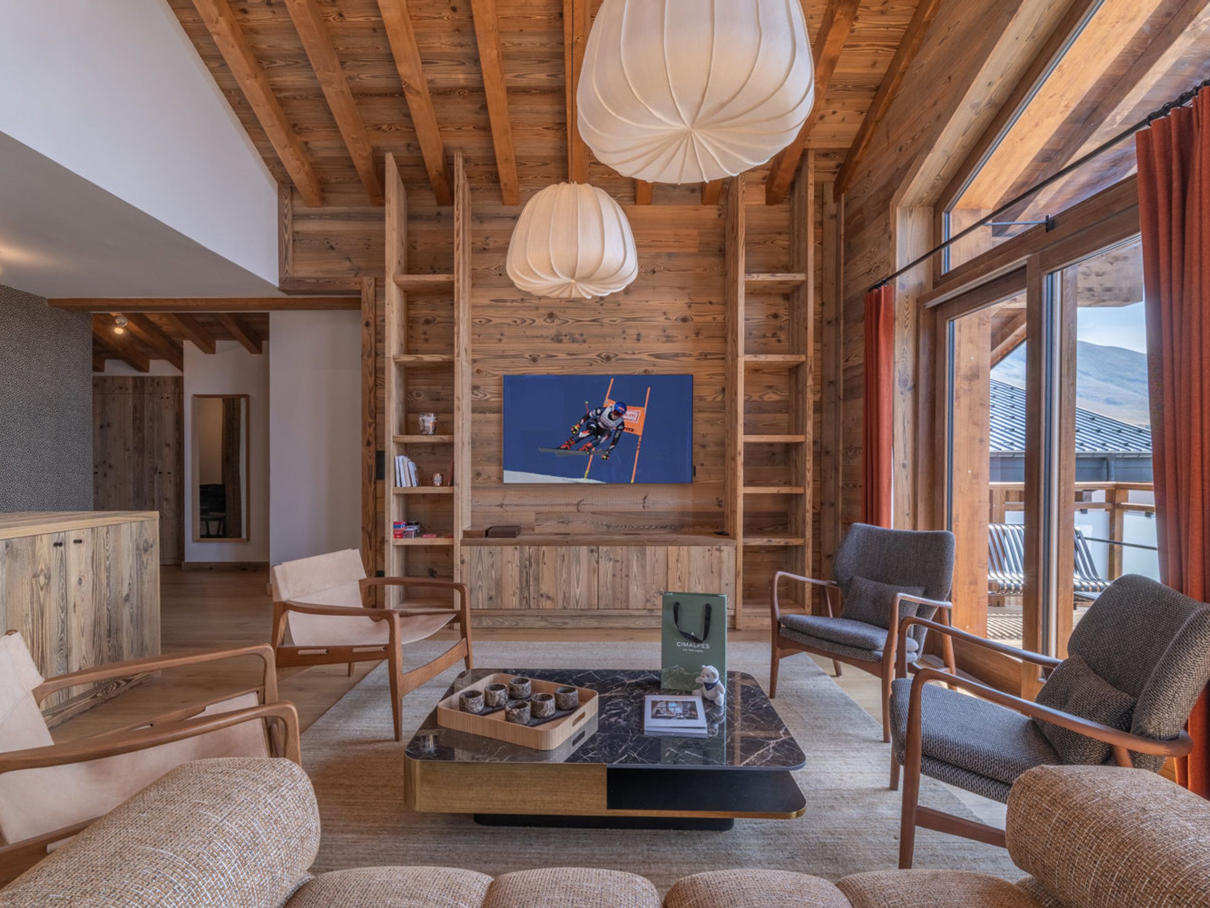 A cozy interior with wooden beams, a fireplace, and a ski-themed painting.