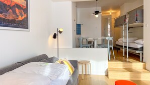 A modern bedroom with a gray sofa, a bunk bed, a small table, and a framed picture on the wall. - Renovated Studio 4 Pers Avoriaz, Mountain View (Avoriaz)