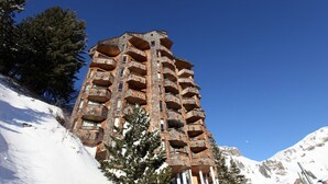 A tall, multi-story building with numerous balconies, surrounded by snow-covered mountains and trees. - Renovated Studio 4 Pers Avoriaz, Mountain View (Avoriaz)