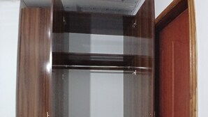 A room with a wooden wardrobe, a mirror, and a red door. - Rhacky Homes Syokimau | Near JKIA 5 - 10 minutes' drive | Free WI-FI & Parking. (Machakos)