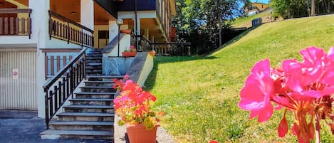 Ein Gebäude mit einer Treppe, die zu einem überdachten Bereich mit Blumentöpfen führt.