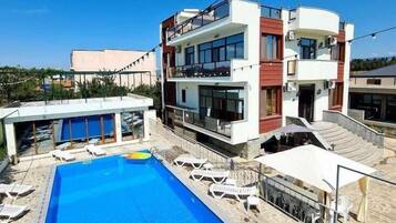 Kauden mukainen ulkouima-allas, aurinkovarjoja, aurinkotuoleja