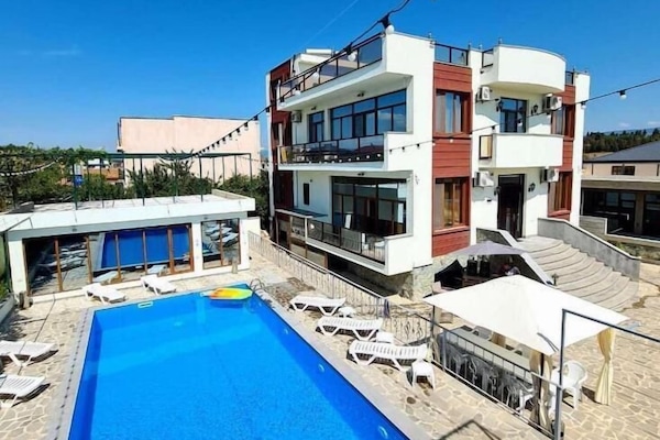 Una piscina al aire libre de temporada, sombrillas