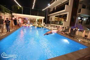 Una piscina al aire libre de temporada, sombrillas, tumbonas