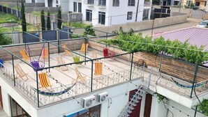 Una terrazza sul tetto con posti a sedere all'aperto, una scala e vista sugli edifici circostanti.