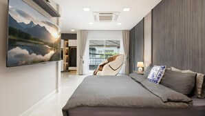 A modern bedroom with a large bed, a chair, and a view of a balcony. - Bangkok's Most Beautiful Modern Villa (Bangkok)