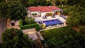 A modern house with a swimming pool, surrounded by lush greenery and a hilly landscape. - Villa Danijela Zadarvillas (Polaca)