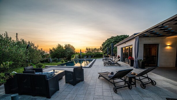 An outdoor patio area with a pool, lounge chairs, and a pergola. - Villa Danijela Zadarvillas (Polaca)