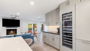 A modern kitchen with white cabinets, a built-in oven, and a large window. - Remodeled Palm Desert Home by El Paseo: Mountain views, pool&spa, outdoor kitchen, sleeps 8 (Palm Desert)