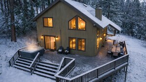 A cabin with a deck, hot tub, and outdoor seating area. - Shaver Escape – Hot Tub Cabin Retreat with AC + Forest Views (Shaver Lake)