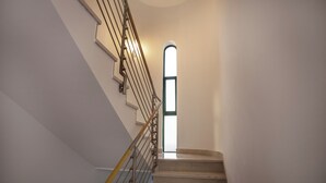 Una escalera con barandilla y un ventanal en la parte superior.