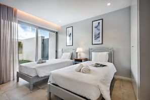Ein Hotelzimmer mit zwei Betten, einem großen Fenster und Bildern an den Wänden.
