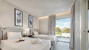 A hotel room with two beds, a balcony with a view, and artwork on the walls. - Villa Violeta - Prime Location, Big-Villa Luxury in the heart of Albufeira (Albufeira)