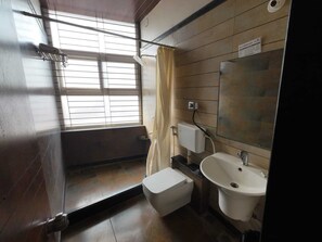 A small bathroom with a toilet, sink, and window.
