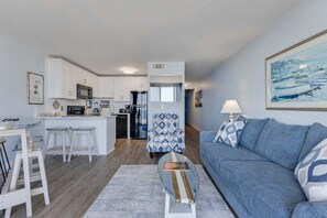 Ein modernes Apartment mit Küche, Essbereich und Wohnzimmer.