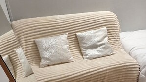 A beige sofa with textured cushions and a wooden floor. - Free room/parking and bus in front (Amiens)