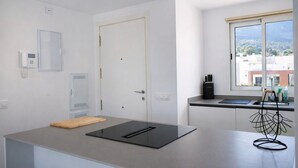 A modern kitchen with a large window, a built-in oven, and a small island with a cutting board. - Ap2147 in Denia With 2 Bedrooms and 1 Bathrooms (Denia)
