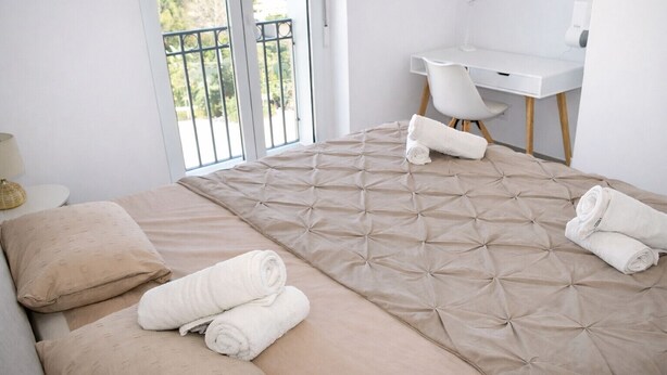 A modern hotel room with a large bed, a desk, and a chair. There is a balcony with a railing and a view of greenery. - Ap2147 in Denia With 2 Bedrooms and 1 Bathrooms (Denia)
