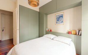 A bedroom with a bed, a green wardrobe, a shelf with books and a framed poster. - VIRGILE • KEYWEEK Family apartment in the heart of Biarritz (Biarritz)