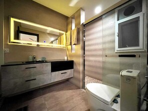 Ein modernes Badezimmer mit Waschtisch, Spiegel, Toilette und Duschkabine.