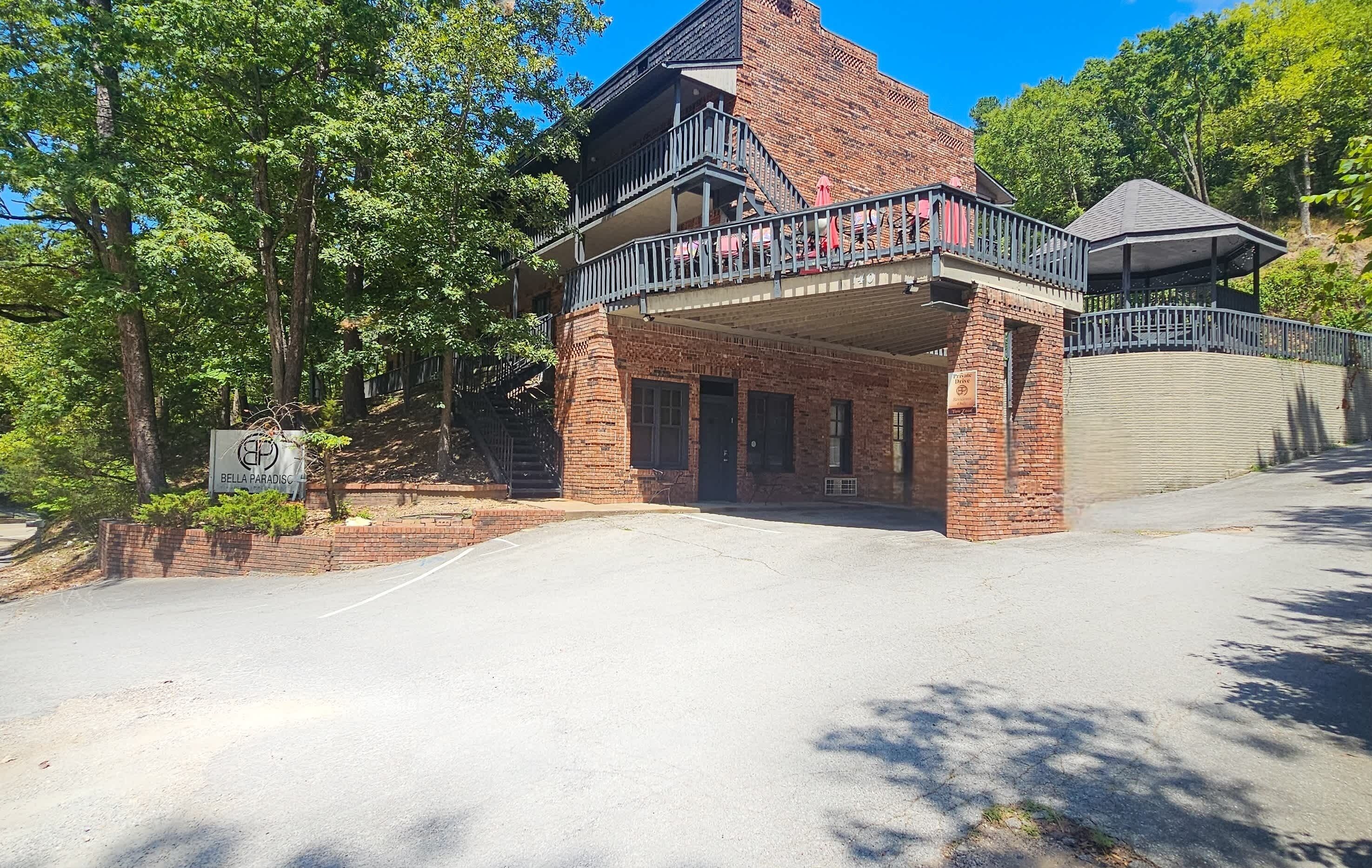 A brick building with a balcony and a covered area.