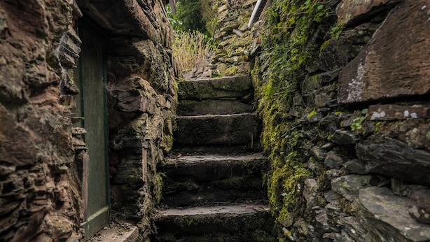 Una estrecha escalera de piedra en un entorno rústico.