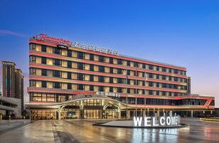 Un hotel de varios pisos con un llamativo letrero de 'Welcome' en la entrada.