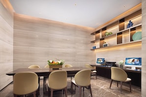 A modern conference room with a long table, several chairs, a desk with a computer, and a shelf with decorative items. - Hampton by Hilton Ningde Lithium Electricity Town (Ningde)
