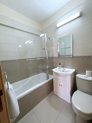 A bathroom with a bathtub, a glass-enclosed shower, a sink, and a toilet. - Sunrise Palette Suites - 2Bedroom 6' away from sea (Xylofagou)