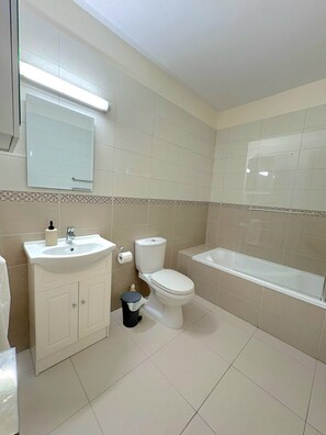 Ein Badezimmer mit Waschbecken, Toilette und Badewanne.
