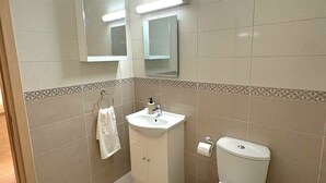 Un bagno con il water, lavandino e specchio.