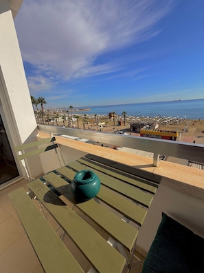 Ein Balkon mit Blick auf Strand und Meer.