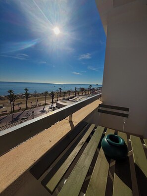 Ein Balkon mit Blick auf einen Strand und das Meer.