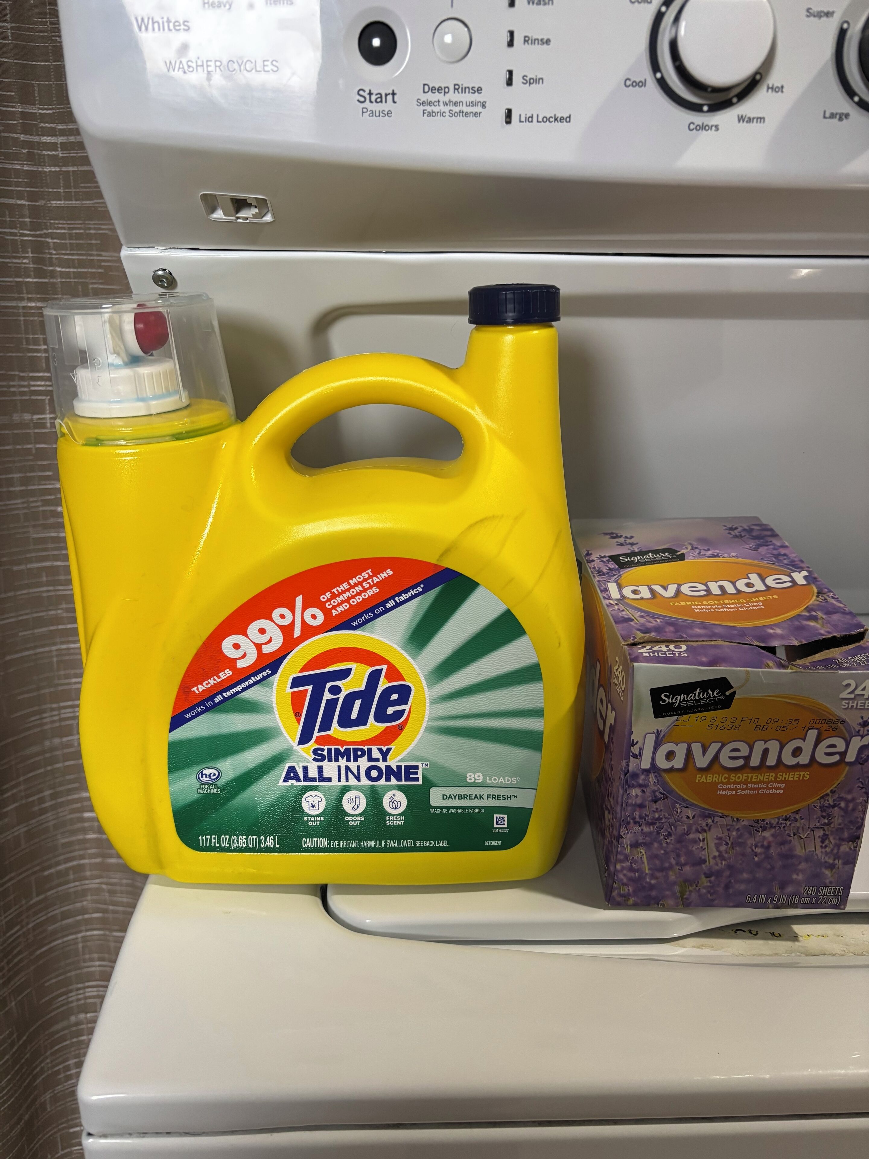 Tide laundry detergent and lavender fabric softener on a washing machine.