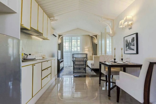 A modern kitchen with white cabinets and a dining area with a table set for four.