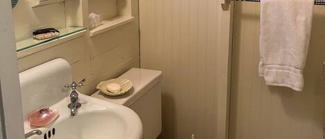 A bathroom with a sink, toilet, and a towel hanging on the wall.