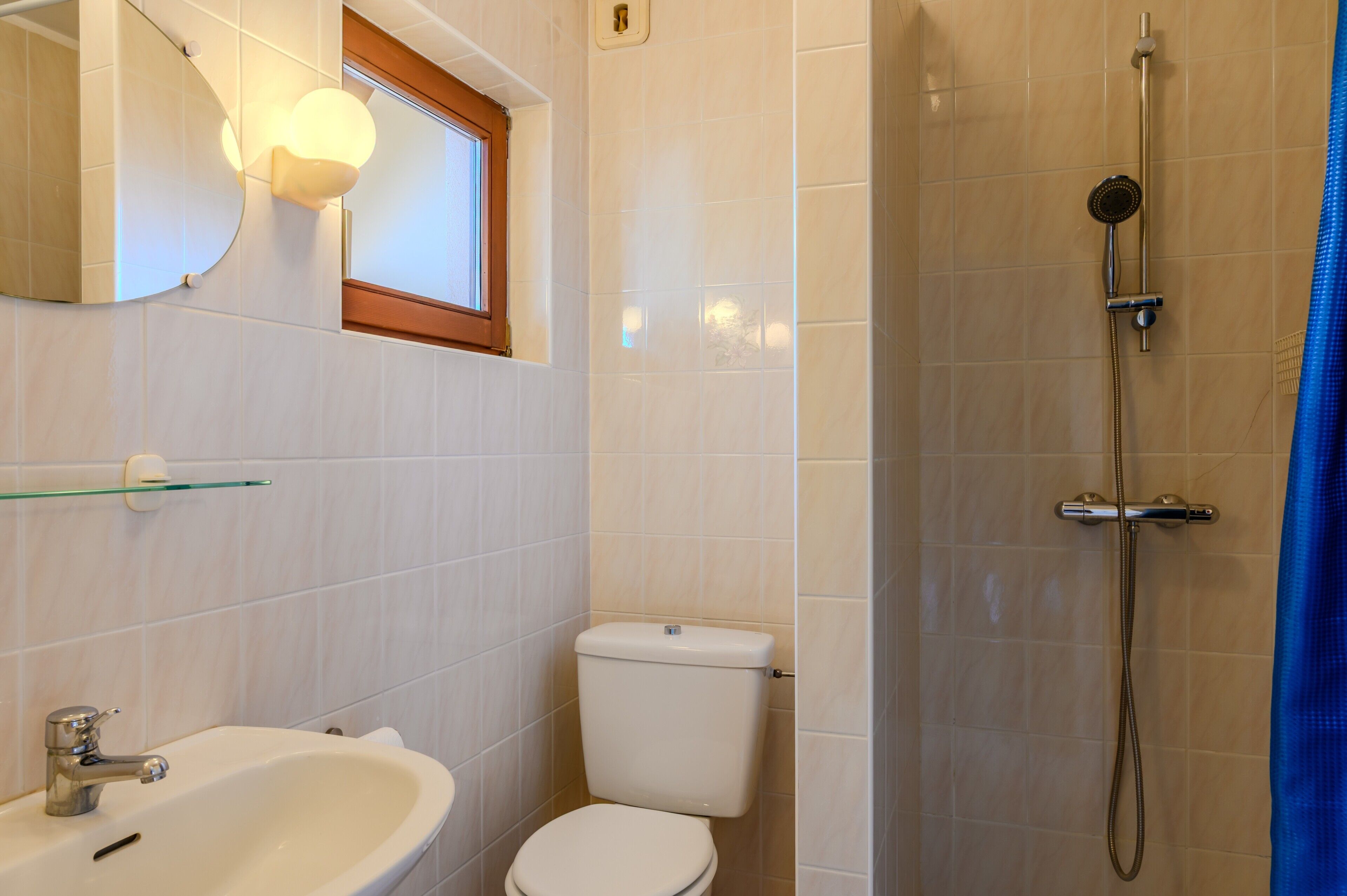A bathroom with a toilet, sink, and shower.