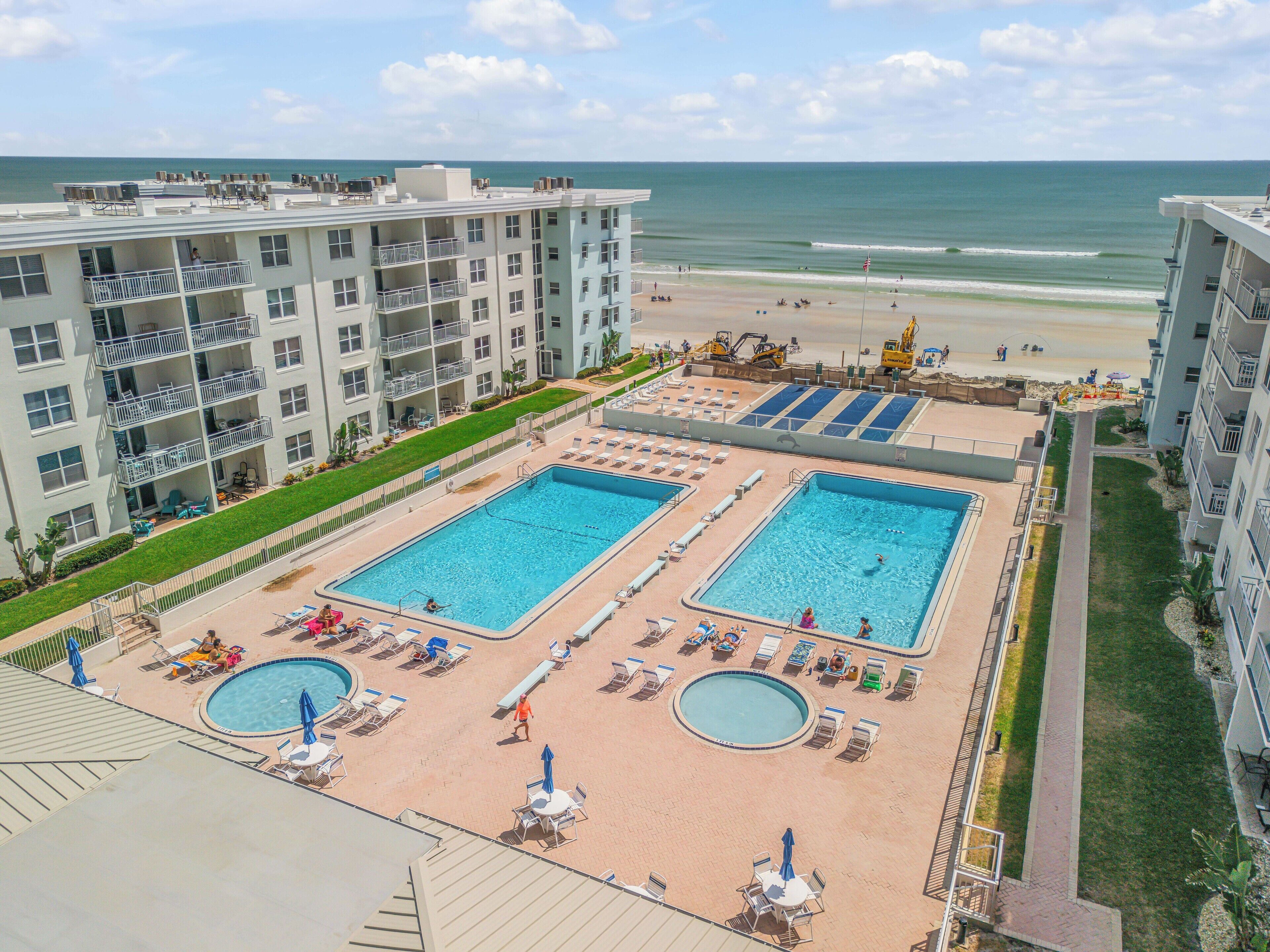 A hotel with multiple swimming pools, a beach, and ocean views.