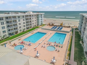 A hotel with multiple swimming pools, a beach, and ocean views.
