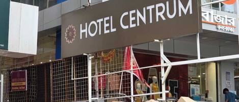 A hotel entrance with a sign reading "HOTEL CENTRUM" and a reception sign indicating the 2nd floor.