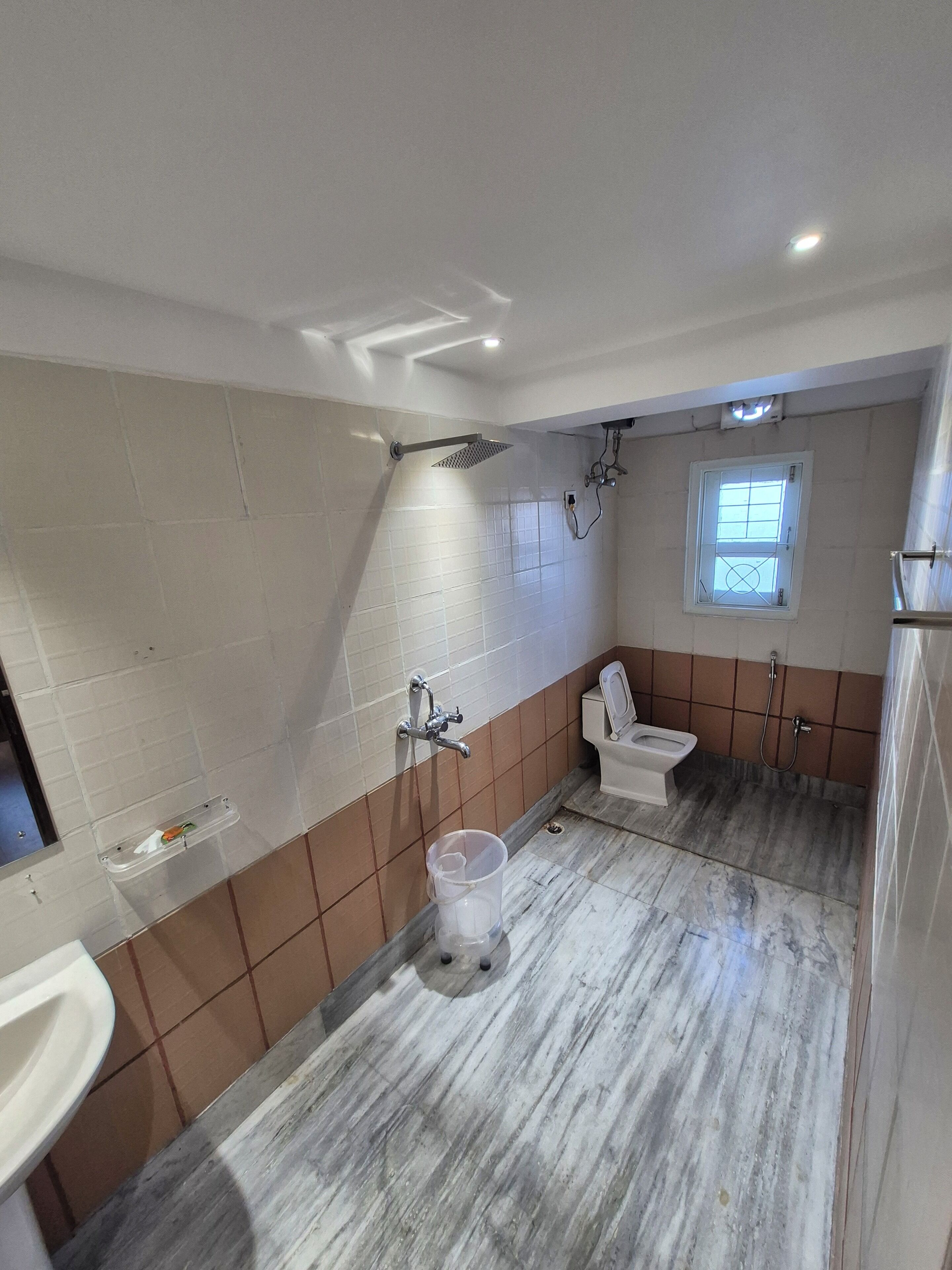 A bathroom with a shower, toilet, and sink.