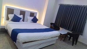 Una camera d'albergo con un letto grande, una scrivania e una sedia.