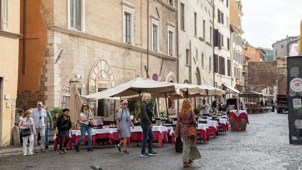 A cobblestone street with outdoor seating at a restaurant, surrounded by historic buildings. - Roxy luxury house Rome (Rome)